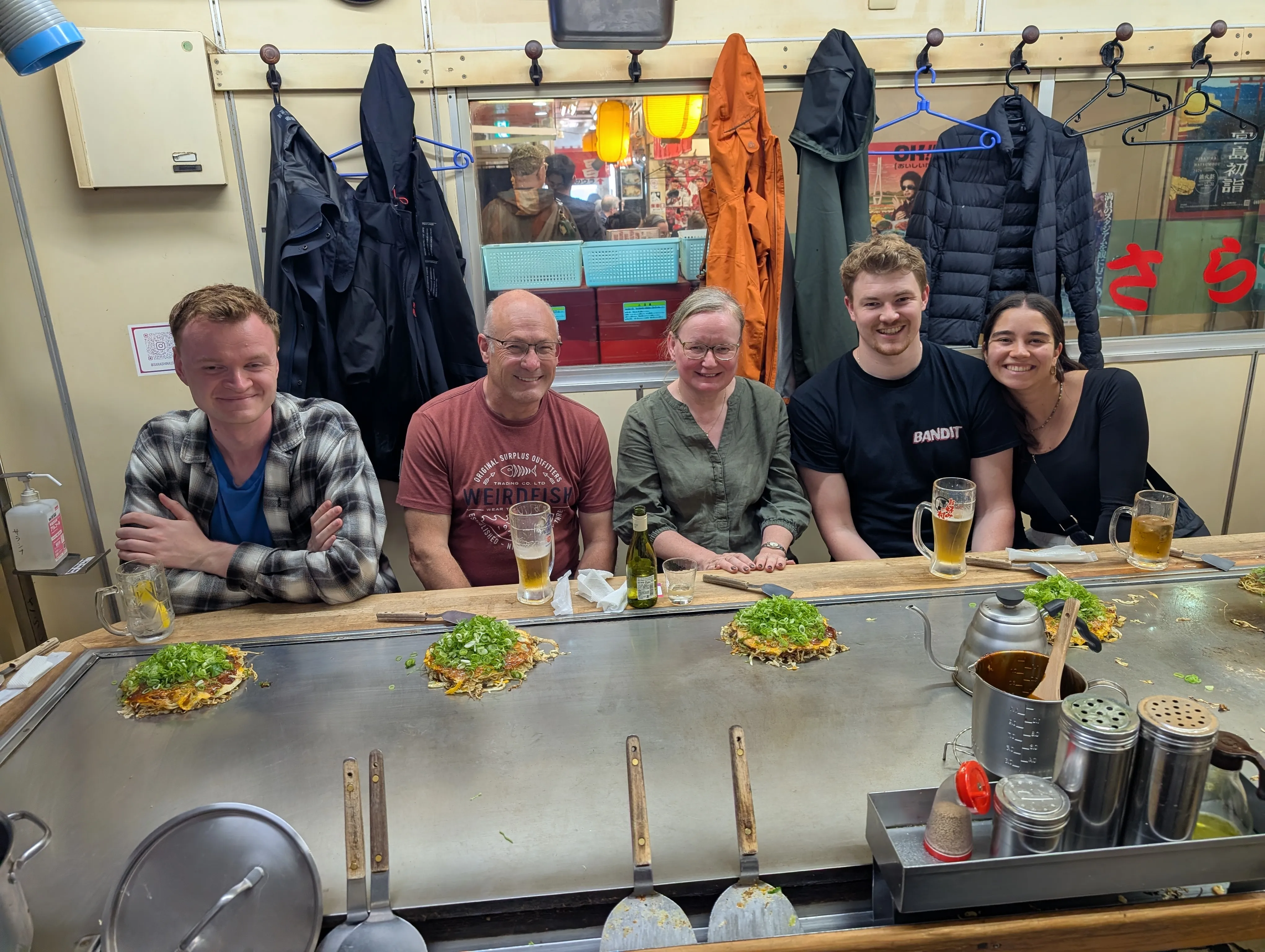 The group at a Hiroshima teppanyaki counter with okonomiyaki on the hotplate